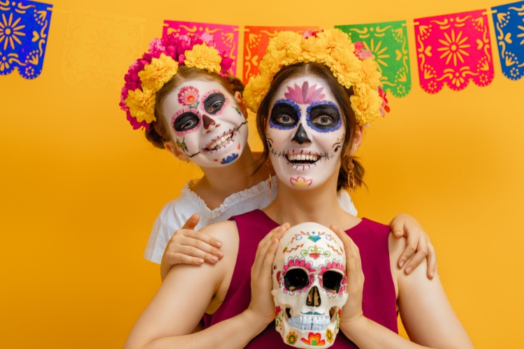 mother and daughter dressed for dia de los muertos