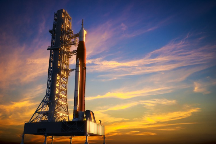 Space rocket standing on a launchpad at sunset, with a colorful sky in the background