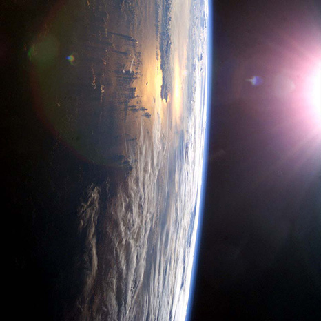 Sunlight reflecting over Earth’s horizon symbolizing a celestial memorial tribute