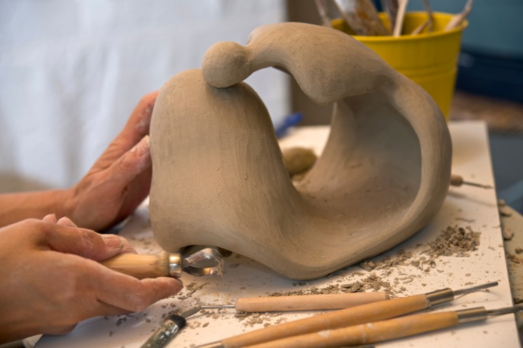 Artisan hands creating a custom memorial sculpture that reflects the spirit of the departed