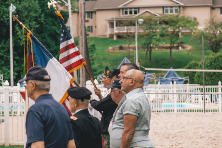 Veterans gathered for a Memorial Day event, holding flags in a solemn ceremony to honor those who served in the military